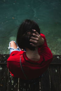 Rear view of woman sitting over lake