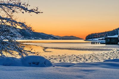 Scenic view of frozen lake against sky during sunset