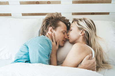 Couple cuddling on bed in home