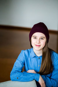 Portrait of smiling young girl sitting at home