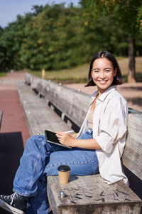 Portrait of young woman sitting on table