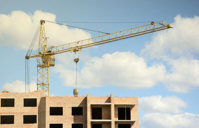 Low angle view of crane against sky