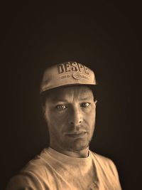 Portrait of young man against black background