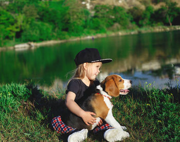 Woman with dog sitting on grass