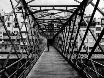 Footbridge over footpath amidst buildings