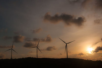 Silhouette of wind turbines at sunset