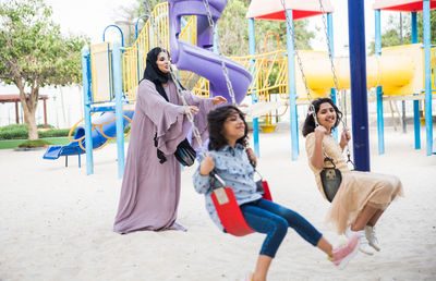 Mother with cheerful daughters enjoying at park