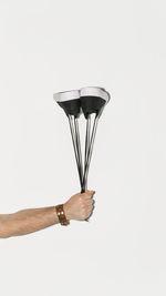 Close-up of hand holding lamp against white background