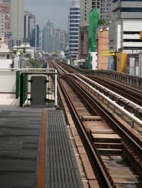 Railroad station platform against buildings in city