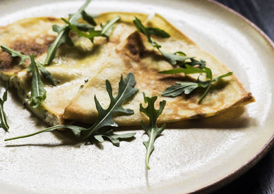 Close-up of arugulas on stuffed pancakes in plate