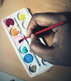High angle view of human hand holding paper