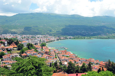 High angle view of townscape by mountain against sky