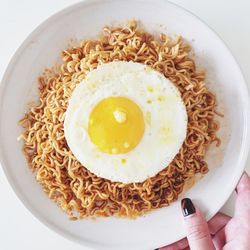 Directly above shot of hand holding noodles in bowl