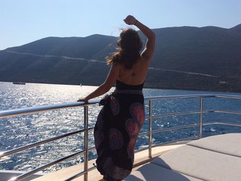 Young woman standing on boat sailing in sea