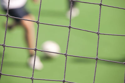 Full frame shot of net against players on soccer field
