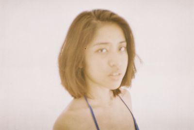 Close-up portrait of young woman over white background