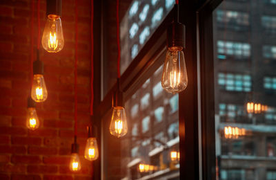 Illuminated light bulb hanging at night