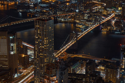 High angle view of illuminated brooklyn bridge over river in city at night