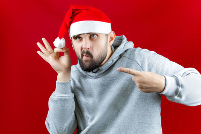 Portrait of man wearing hat against red background