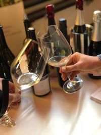 Midsection of woman holding wine glass on table at restaurant