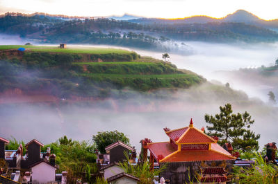 High angle view of houses and trees by mountains