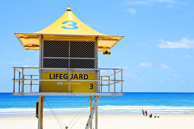 Lifeguard hut on beach against blue sky