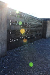 Text on wall in city against clear sky