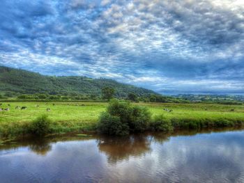 Scenic view of lake against cloudy sky