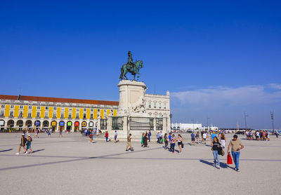 Group of people on statue against the sky