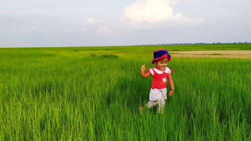 Full length of child on field against sky