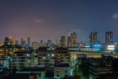 Illuminated buildings in city against sky