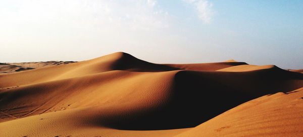 Sand dunes in desert against sky