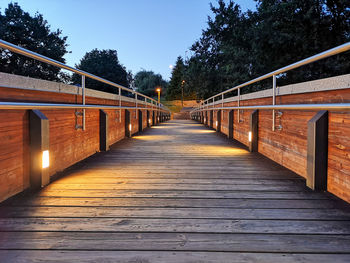 Empty footbridge along trees