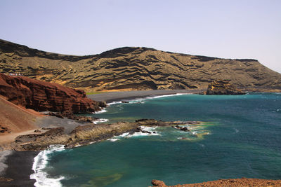 Scenic view of sea and mountains against clear sky