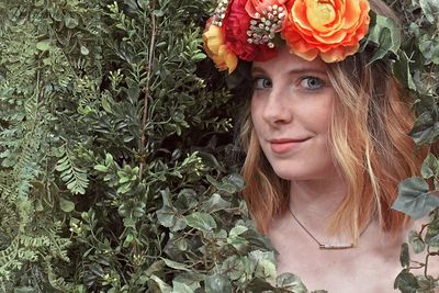 Portrait of beautiful young woman in red flowering plants