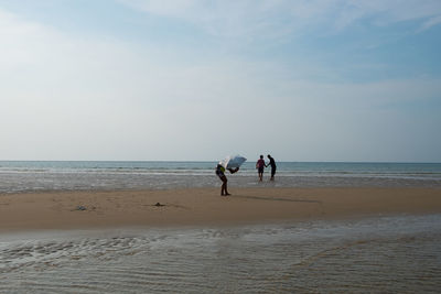 People on beach against sky