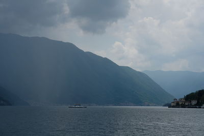 Scenic view of sea and mountains against sky