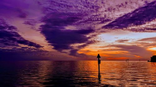 Scenic view of sea against dramatic sky during sunset