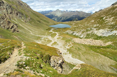 Scenic view of stream amidst mountains against sky