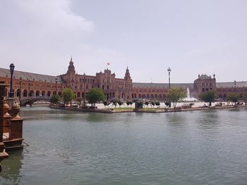 Arch bridge over river against buildings in city