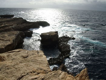 Rocks on sea shore against sky