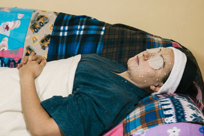 Low section of man lying on bed