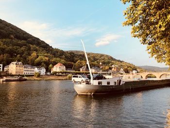 Sailboats moored on river against sky