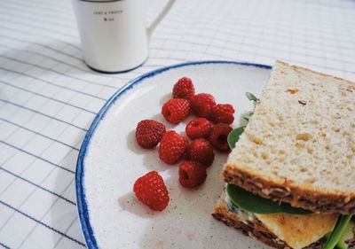 Close-up of sandwich and raspberries on plate