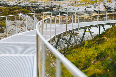 Footbridge by grass and rock formation