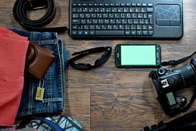 Directly above shot of technologies and personal accessories on wooden table