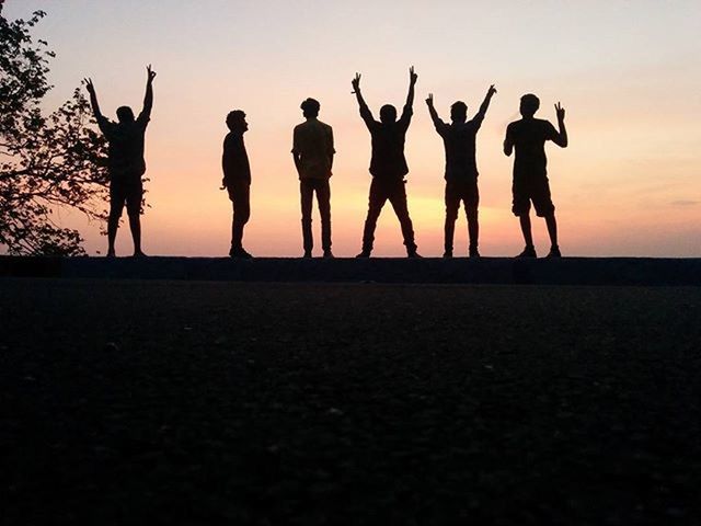 silhouette, sunset, togetherness, men, standing, clear sky, copy space, leisure activity, lifestyles, sky, orange color, person, full length, friendship, outdoors, nature, outline, dusk, large group of people