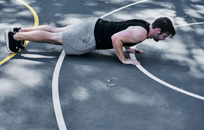 Side view of man doing pull-ups on road