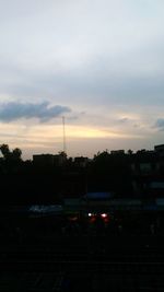 Silhouette of factory against sky during sunset