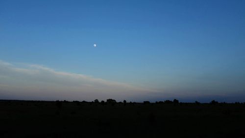 Scenic view of silhouette field against sky at sunset